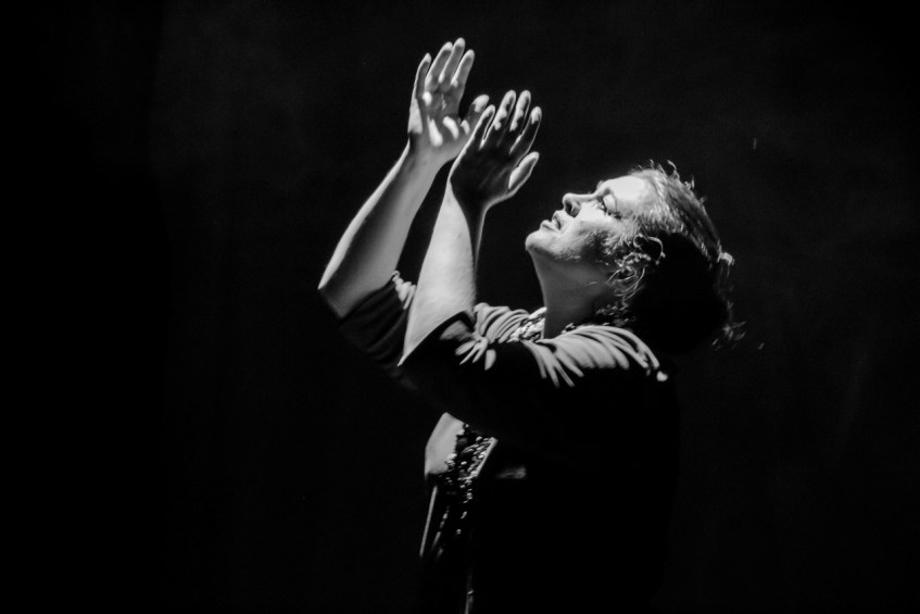 Black and white image of woman with hands up to the light