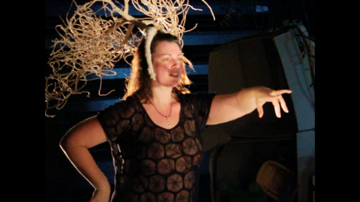 Image of woman with a headdress stretching out arm